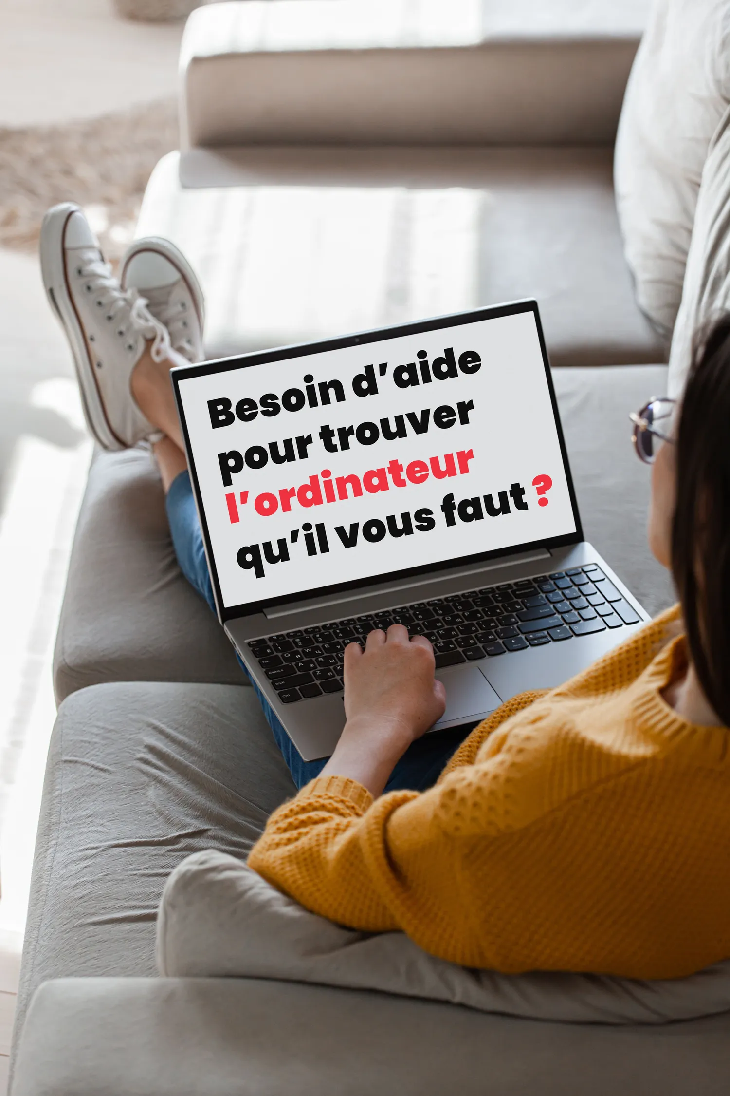 Photographie d'une femme assise sur un canapé avec un ordinateur portable sur les cuisses